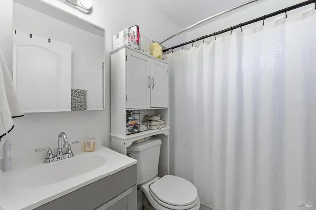 a bathroom with a sink a toilet and shower curtain