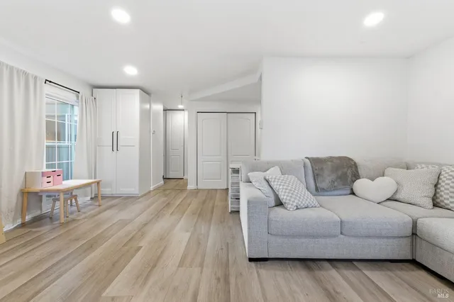 a living room with furniture and wooden floor