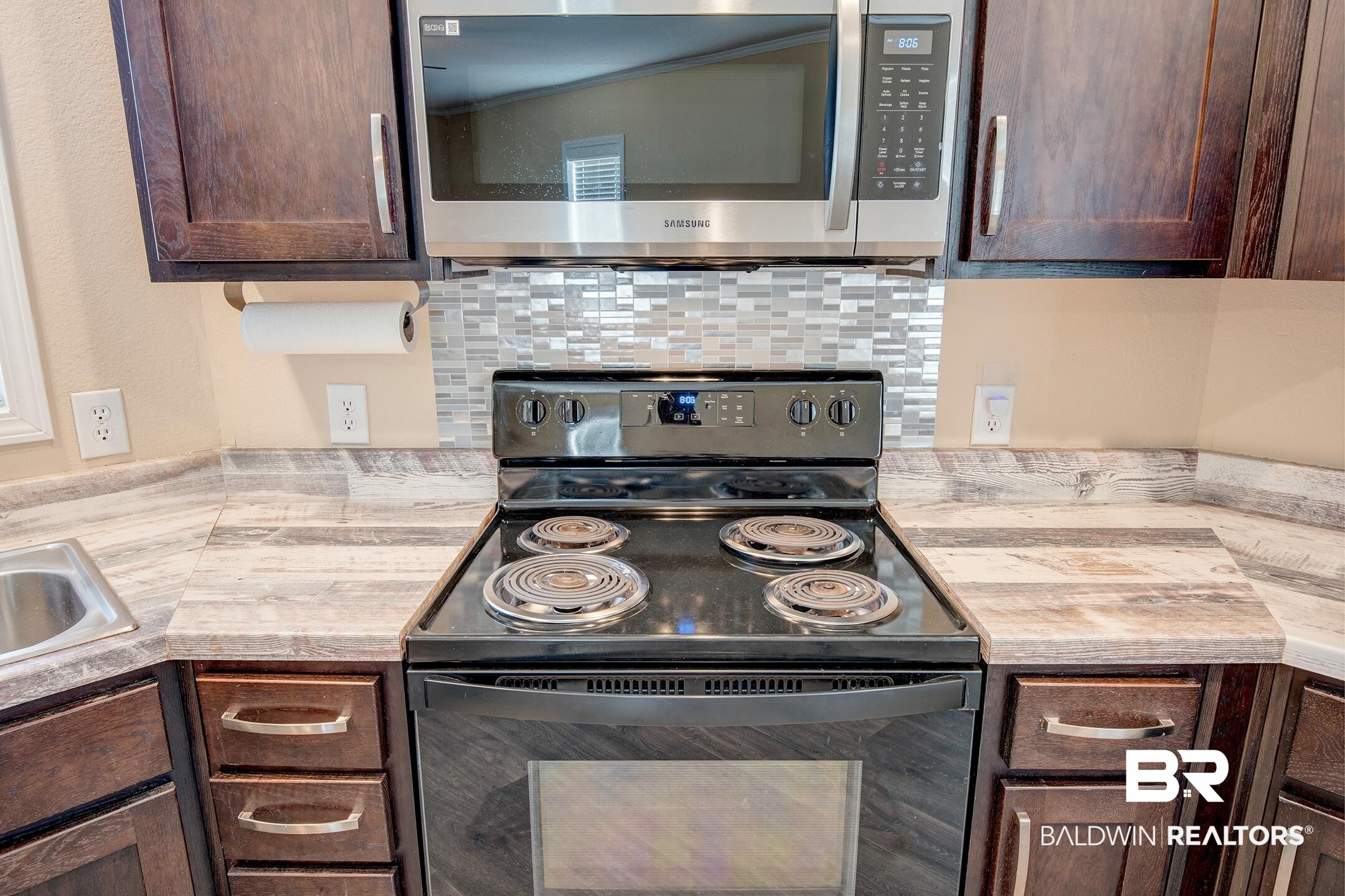 21859 West Side Loop Silverhill, AL 36576 - Photo 15 of 24 Kitchen with electric range, dark brown cabinets, and decorative backsplash