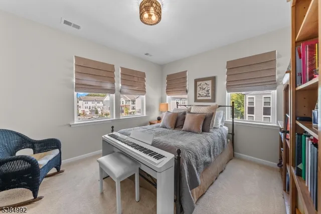 a bedroom with a bed a couch and a flat tv screen on dresser