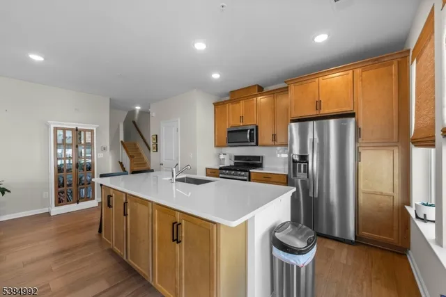 a kitchen with kitchen island a counter top space a sink stainless steel appliances and cabinets