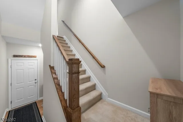 a view of staircase with wooden floor and white walls