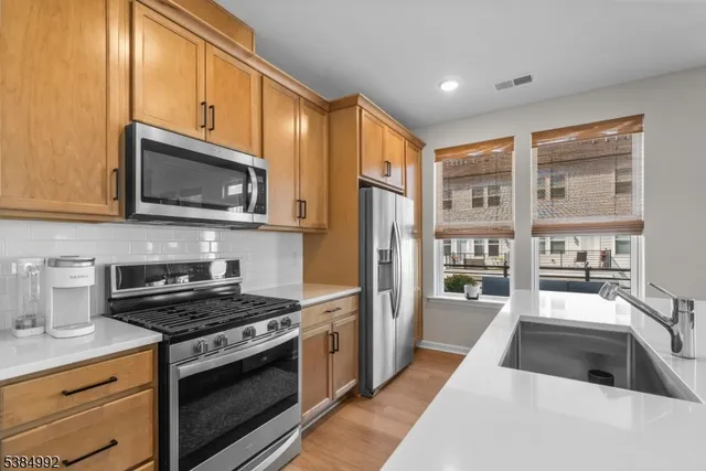 a kitchen with stainless steel appliances granite countertop a stove a sink and a microwave