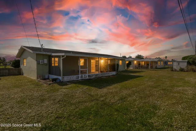 a view of a patio with a table and chairs under an umbrella