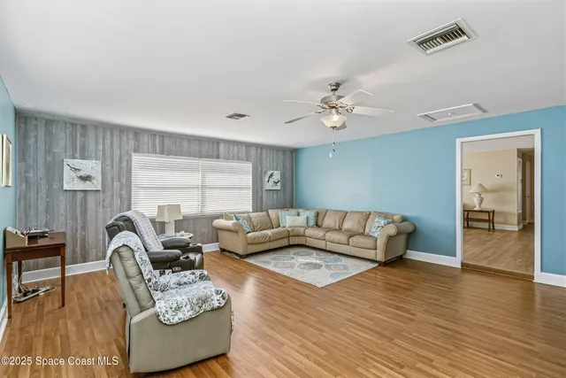 a living room with furniture a flat screen tv and a couch