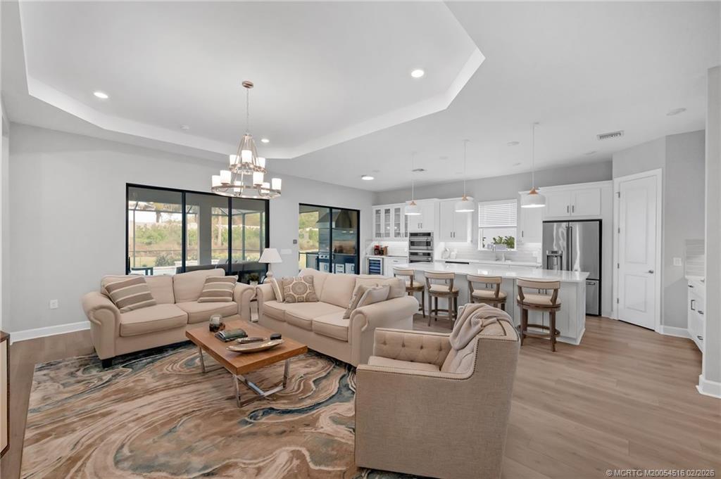 15111 Pescara Street Naples, FL 34114 - Photo 14 of 43 a living room with furniture and a chandelier