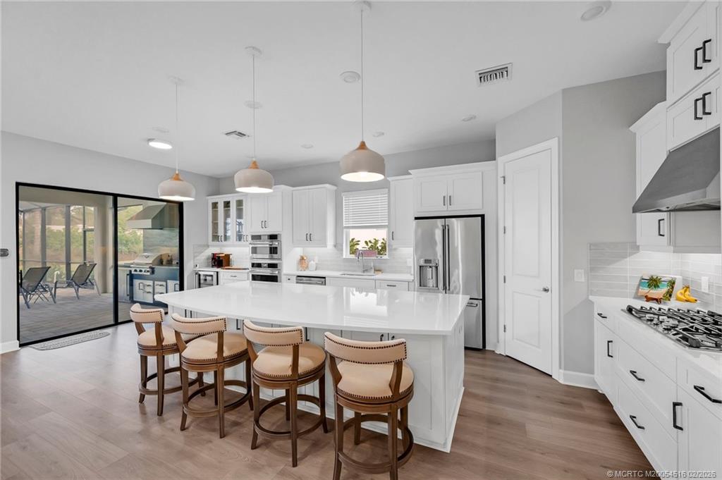 15111 Pescara Street Naples, FL 34114 - Photo 9 of 43 a large kitchen with a table and chairs