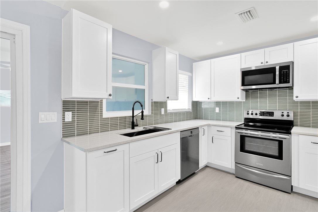 669 Vocelle Avenue Sebastian, FL 32958 - Photo 10 of 34 a kitchen with white cabinets and stainless steel appliances