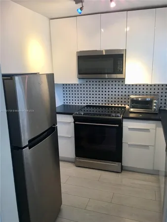 a kitchen with stainless steel appliances granite countertop a refrigerator and a stove