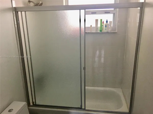 a bathroom with a glass shower door