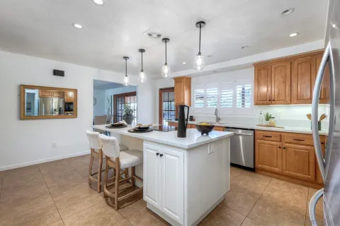 a kitchen with stainless steel appliances granite countertop a sink a stove a refrigerator a microwave oven with white cabinets and wooden floor