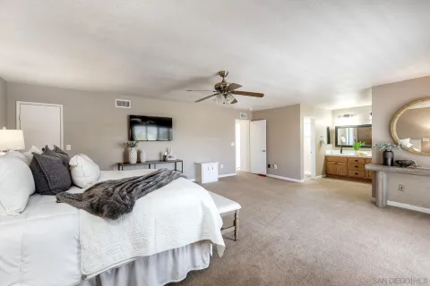 a bedroom with a large bed and a view of living room