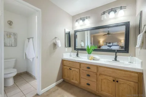 a bathroom with a double vanity sink toilet and mirror