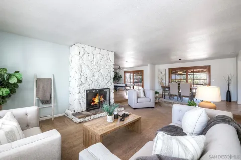 a living room with furniture fireplace and a large window