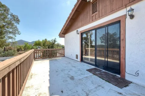 a view of a balcony with floor to ceiling window and wooden fence