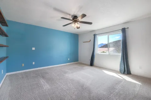 an empty room with fan and windows
