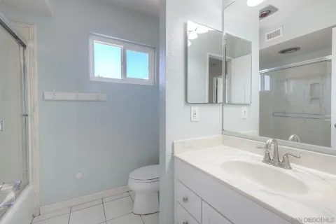 a bathroom with a granite countertop sink a toilet and a mirror