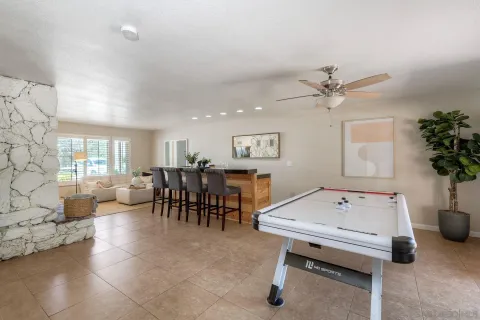 a living room with furniture and potted plants with wooden floor
