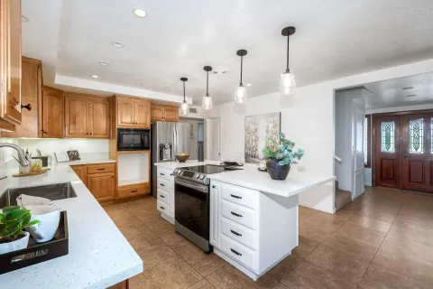 a kitchen with stainless steel appliances kitchen island granite countertop a sink a stove and a wooden floors