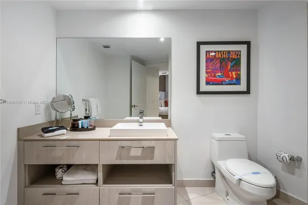 a bathroom with a toilet a sink and mirror