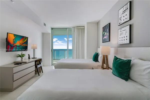 a bedroom with a bed and a flat screen tv