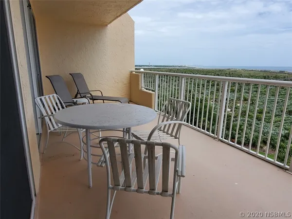a balcony with chairs and a table