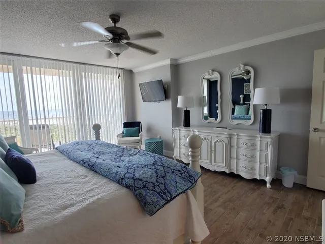 a bedroom with a bed a ceiling fan and a dresser