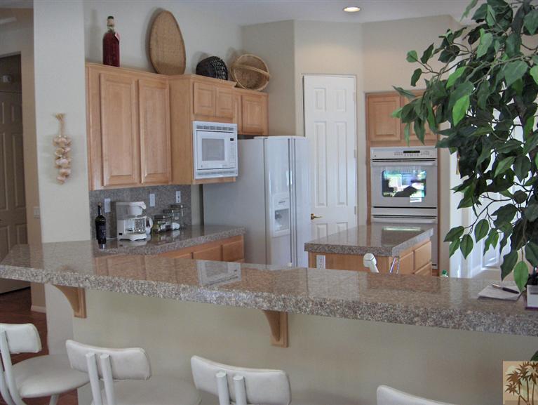 54255 Riviera La Quinta, CA 92253 - Photo 4 of 8 a kitchen with stainless steel appliances granite countertop a sink a stove and a refrigerator
