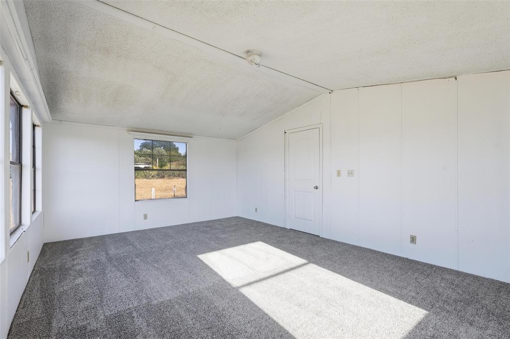 1491 County Road 319, Unit B Cleburne, TX 76033 - Photo 11 of 24 a view of empty room with window and wooden floor