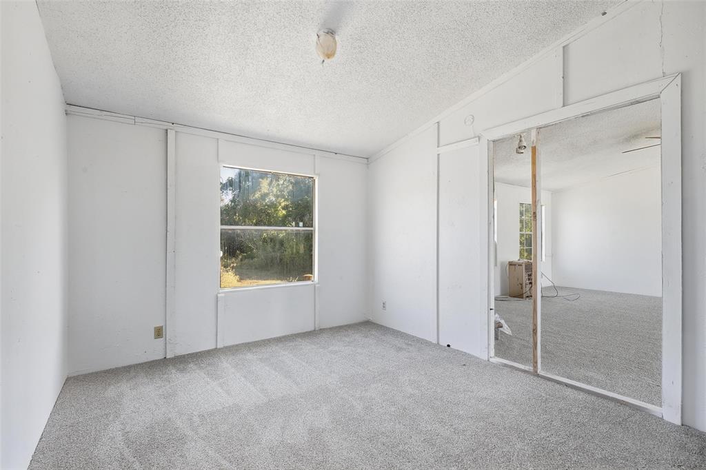 1491 County Road 319, Unit B Cleburne, TX 76033 - Photo 15 of 24 a view of an empty room with window and closet area
