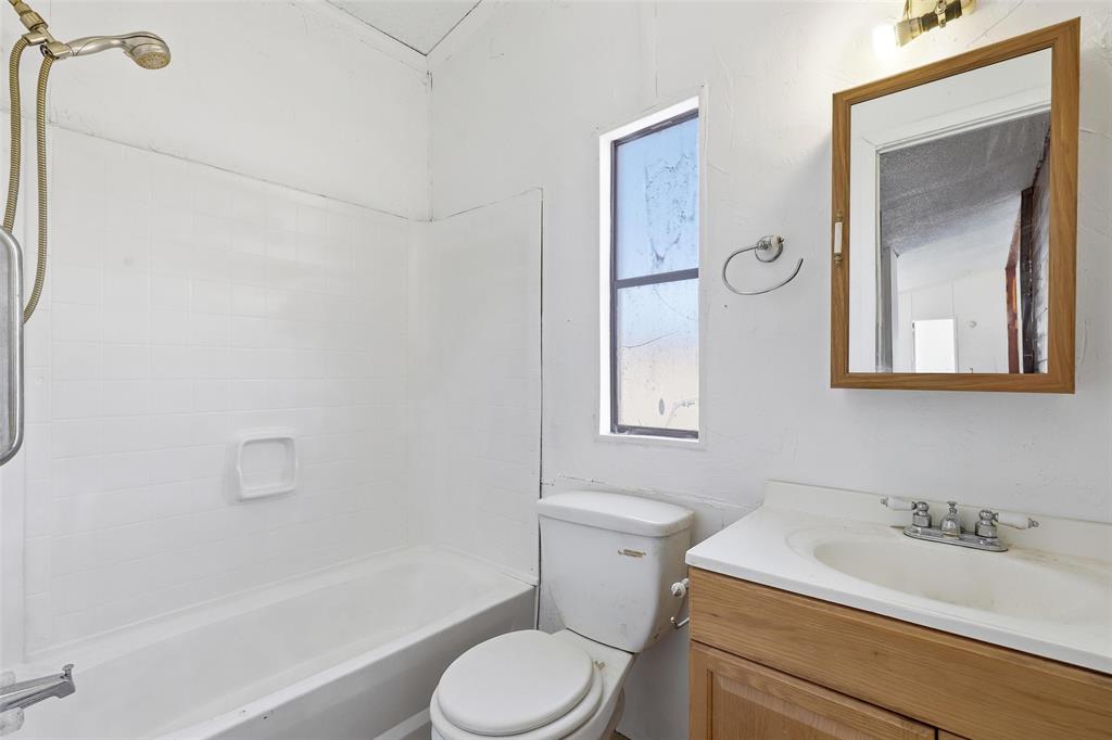 1491 County Road 319, Unit B Cleburne, TX 76033 - Photo 16 of 24 a bathroom with a sink toilet vanity and shower
