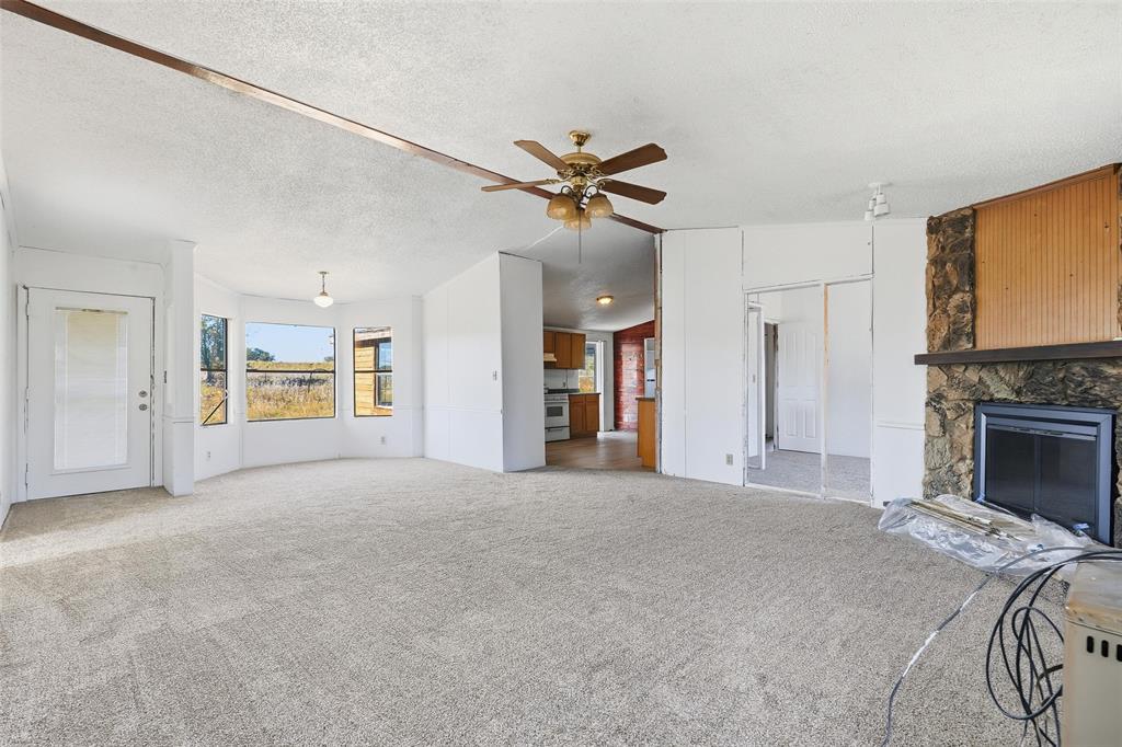 1491 County Road 319, Unit B Cleburne, TX 76033 - Photo 6 of 24 a large bed with a fireplace in it