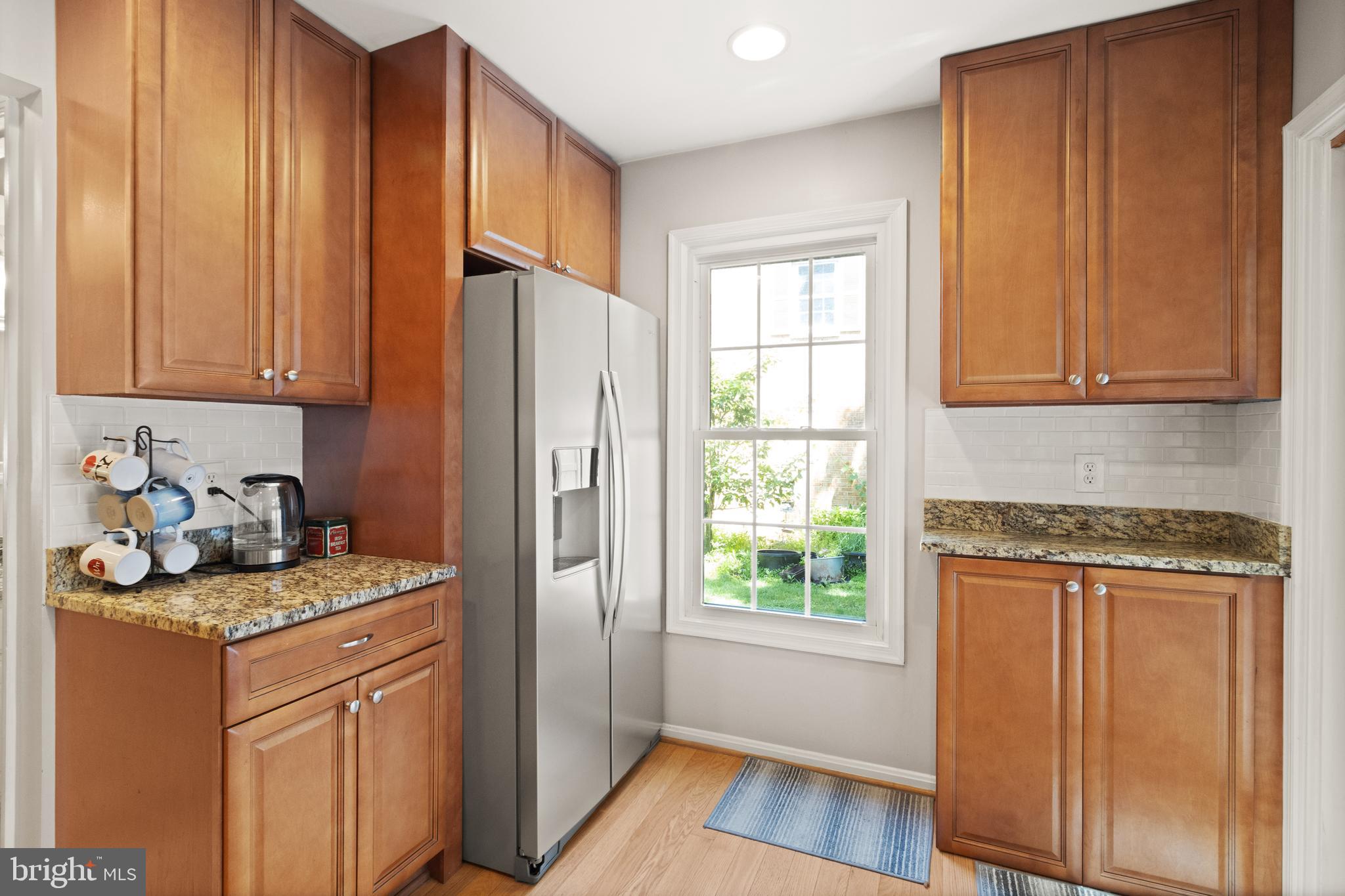 8573 Tyrolean Way Springfield, VA 22153 - Photo 12 of 32 a kitchen with a refrigerator stove and wooden cabinets