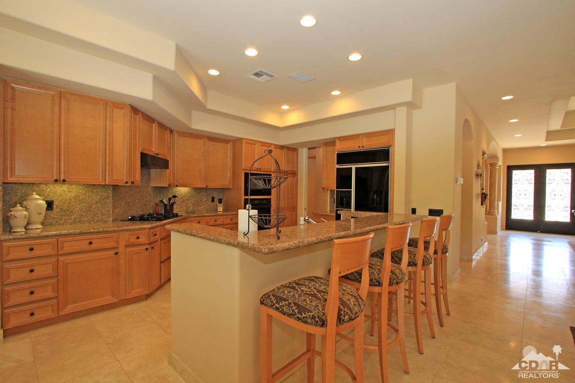 4 Mesquite Ridge Lane Rancho Mirage, CA 92270 - Photo 19 of 62 a kitchen with stainless steel appliances granite countertop a stove top oven a sink a dining table and chairs with wooden floor