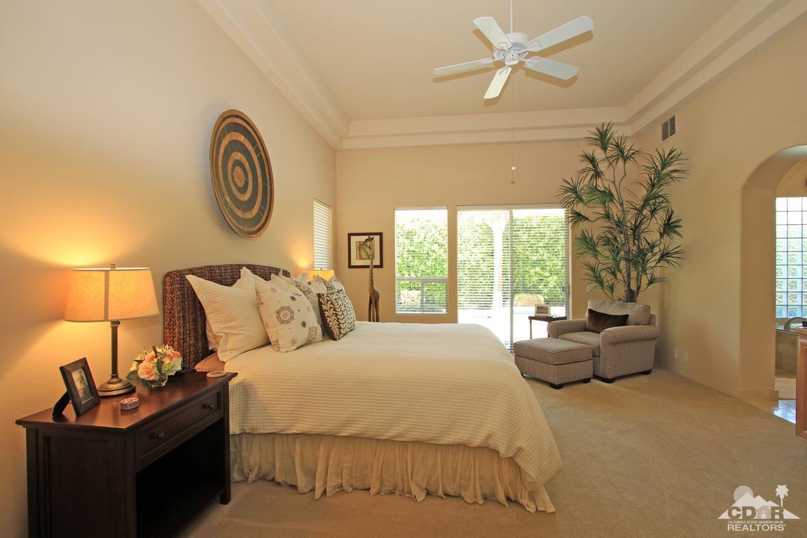 4 Mesquite Ridge Lane Rancho Mirage, CA 92270 - Photo 30 of 62 a bedroom with a bed and a chandelier