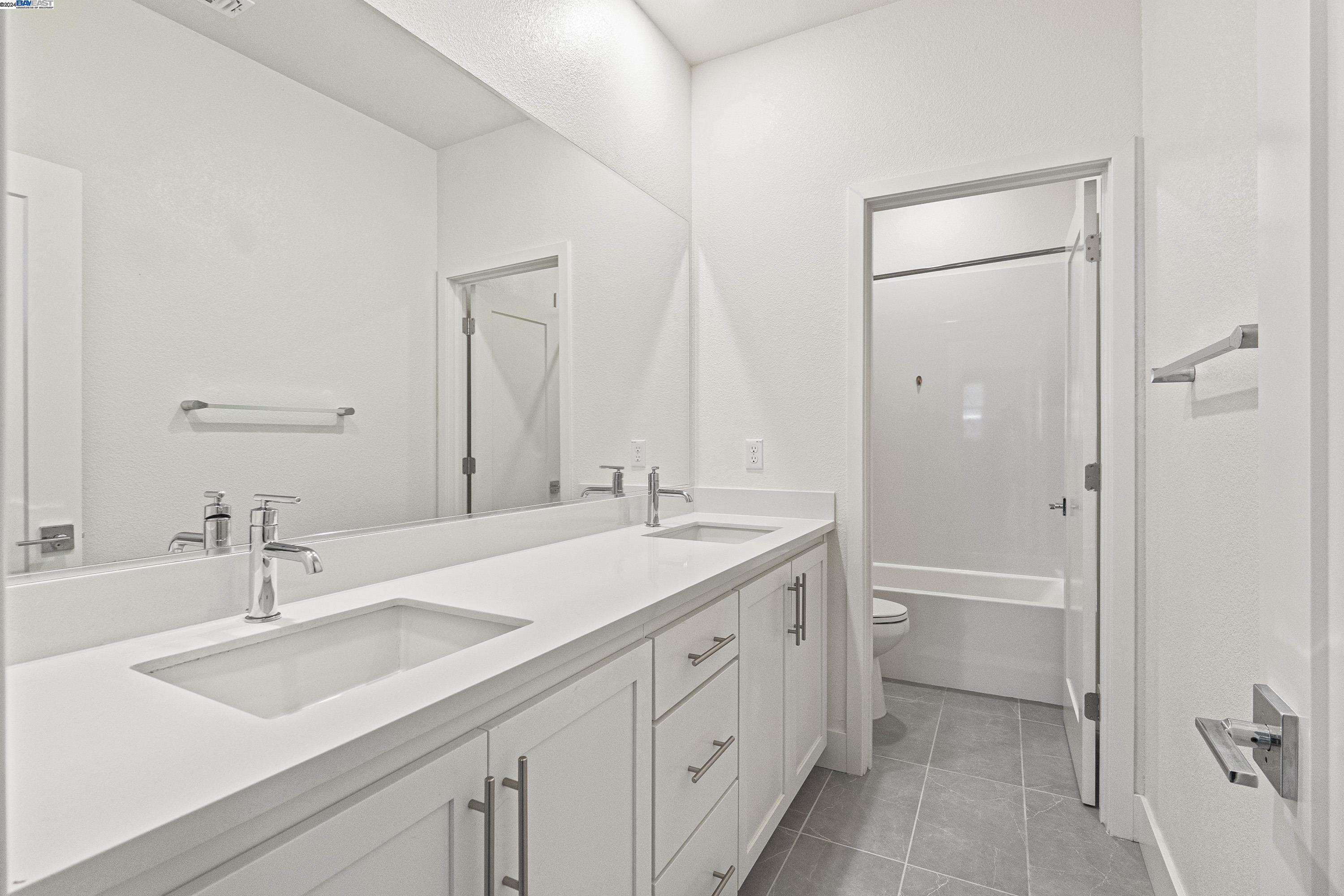 9657 Pontoon Way Newark, CA 94560 - Photo 27 of 46 a bathroom with a double vanity sink mirror double and a bathtub