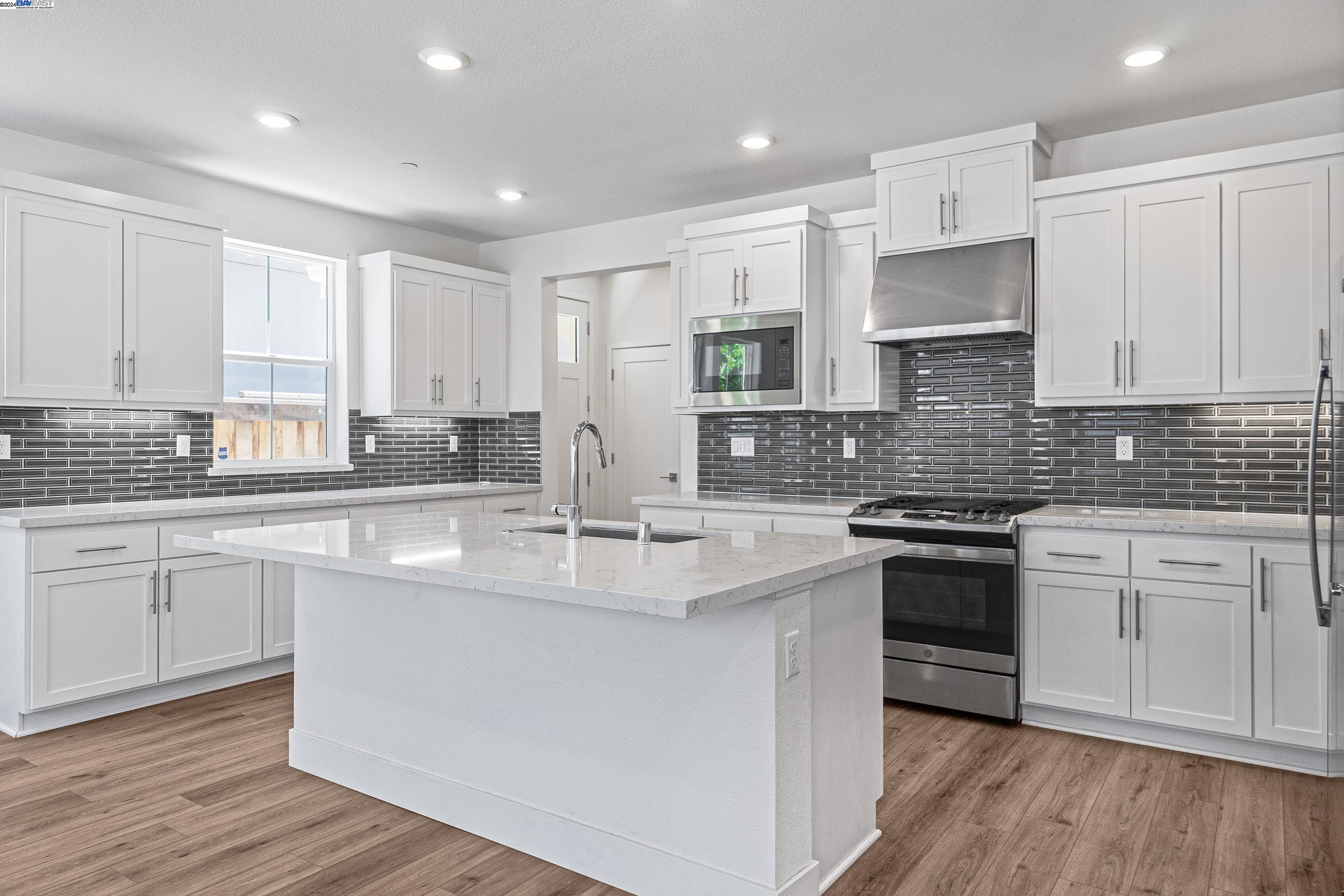 9657 Pontoon Way Newark, CA 94560 - Photo 4 of 46 a large kitchen with stainless steel appliances granite countertop a stove a sink and white cabinets