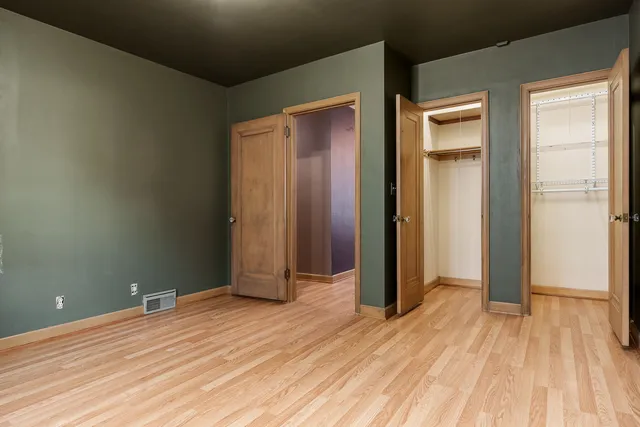 an empty room with wooden floor and closet