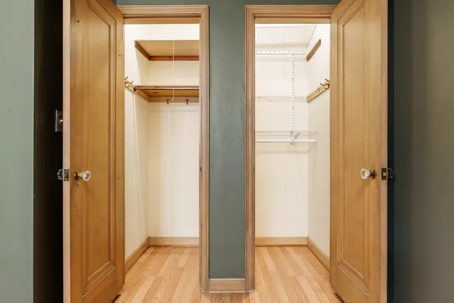 a view of walk in closet with wooden floor