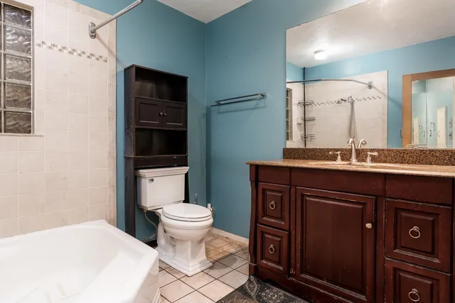 a bathroom with a sink a toilet a mirror and shower