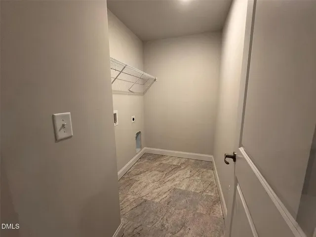 a view of an empty room with closet and wooden door