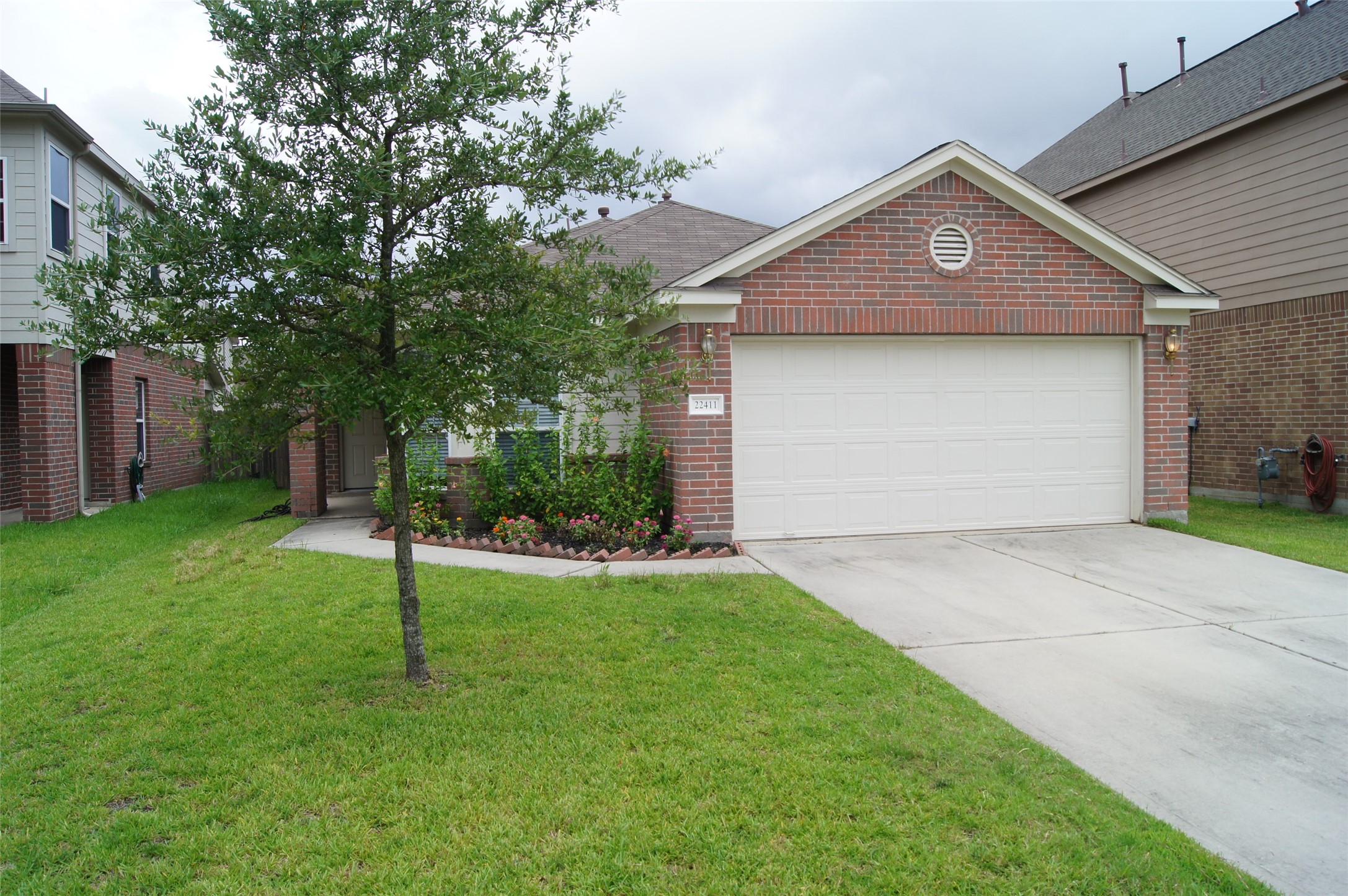22411 HighPoint Pines Drive.
Two-car garage with a double-wide driveway. Mature oak tree in the front yard.