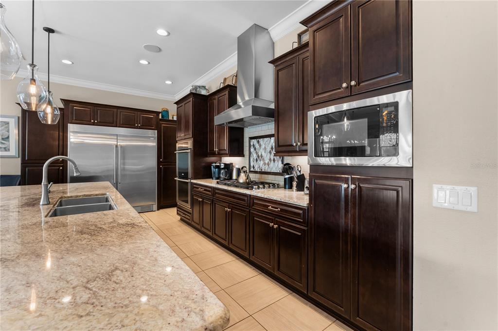 600 Muirfield Loop Reunion, FL 34747 - Photo 12 of 95 a kitchen with granite countertop a refrigerator and a stove top oven