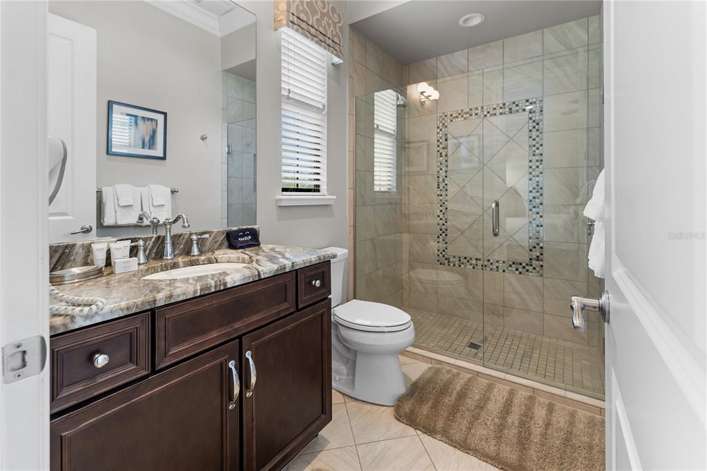 600 Muirfield Loop Reunion, FL 34747 - Photo 33 of 95 a bathroom with a granite countertop sink toilet and shower