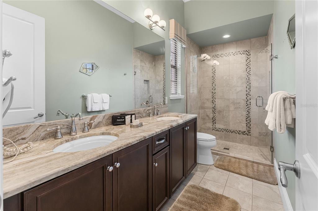 600 Muirfield Loop Reunion, FL 34747 - Photo 79 of 95 a bathroom with a granite countertop double vanity sink mirror double and shower