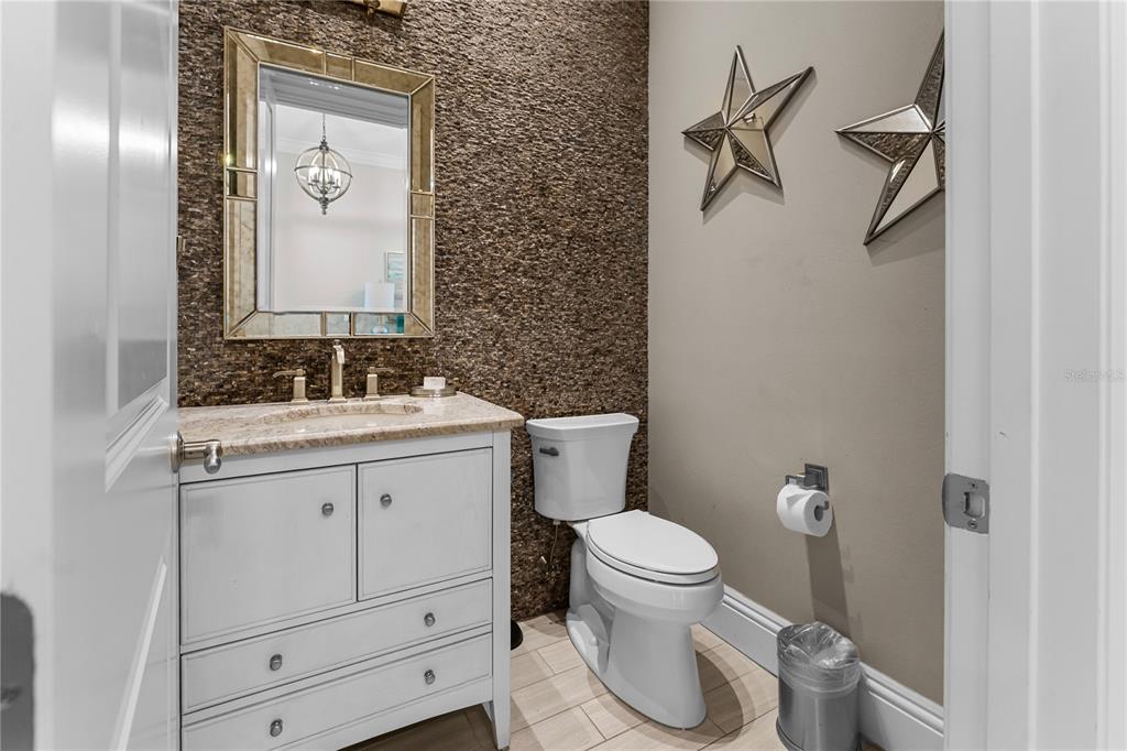 600 Muirfield Loop Reunion, FL 34747 - Photo 9 of 95 a bathroom with a granite countertop toilet sink and mirror