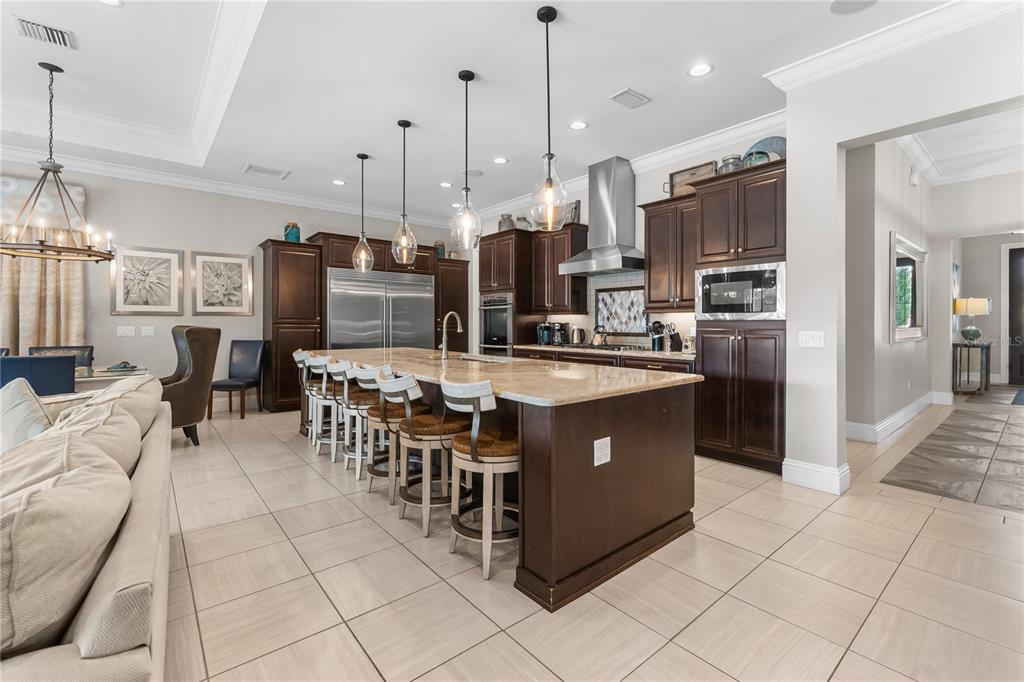 600 Muirfield Loop Reunion, FL 34747 - Photo 10 of 95 a kitchen with stainless steel appliances kitchen island granite countertop a stove and a refrigerator