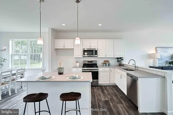 a kitchen with stainless steel appliances a sink a stove a refrigerator and wooden cabinets