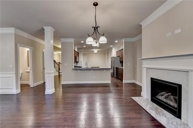 a view of a room with wooden floor and a kitchen