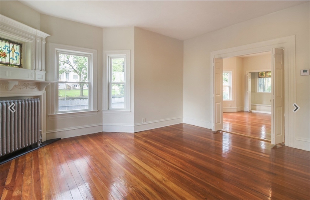 31 Garland Street, Unit 1 Chelsea, MA 02150 - Photo 3 of 9 an empty room with wooden floor and windows
